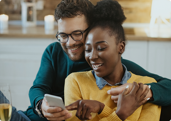 Casal sorrindo e olhando para celular